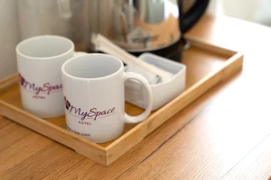 In-room coffee and tea setup with MySpace Hotel branded mugs and electric kettle, providing guests with a cozy stay experience.