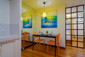 Modern dining area inside MySpace Windsor studio suite with bright chairs and artistic wall decor.
