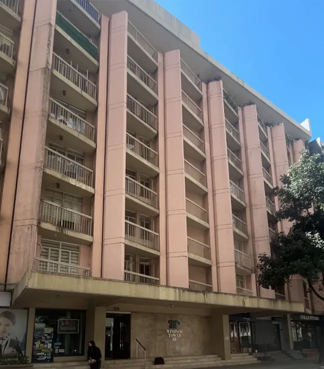 Exterior view of Windsurf Tower, home of MySpace Hotel Windsurf, featuring a tall pink facade with balconies and modern architecture.