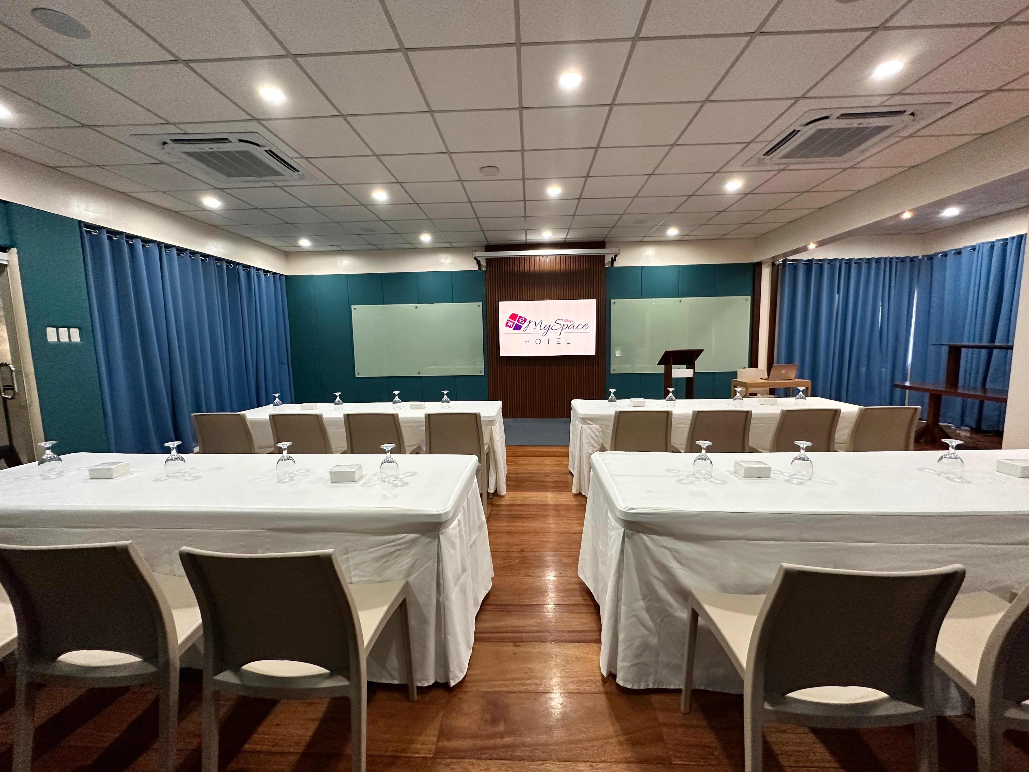 Meeting room in Taguig set up conference-style facing the presentation screen at Hotel MySpace BGC