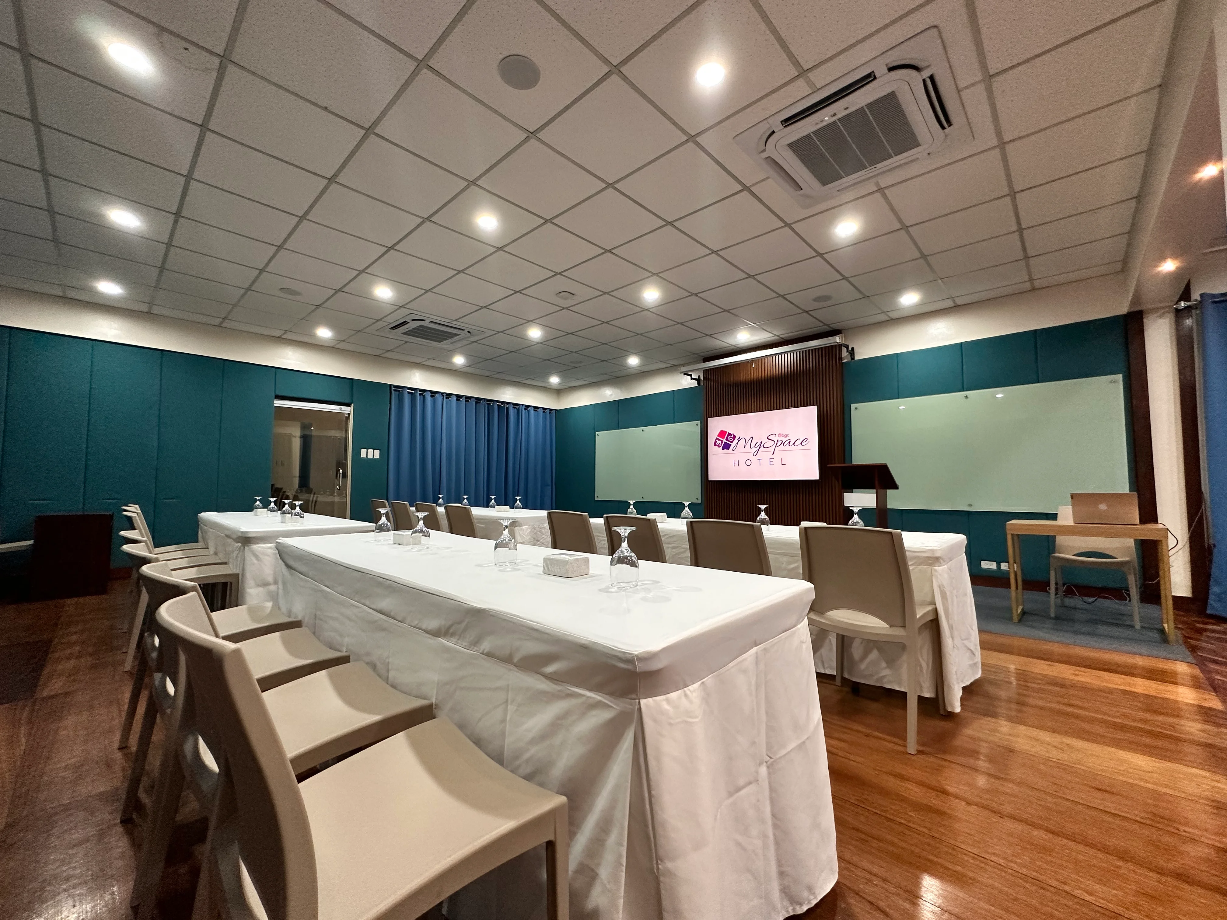 Training venue in BGC with U-shape tables, presentation screen and lectern at Hotel MySpace